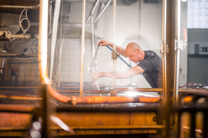 Man working in the process of malting barley. Man working in the process of malting barley.