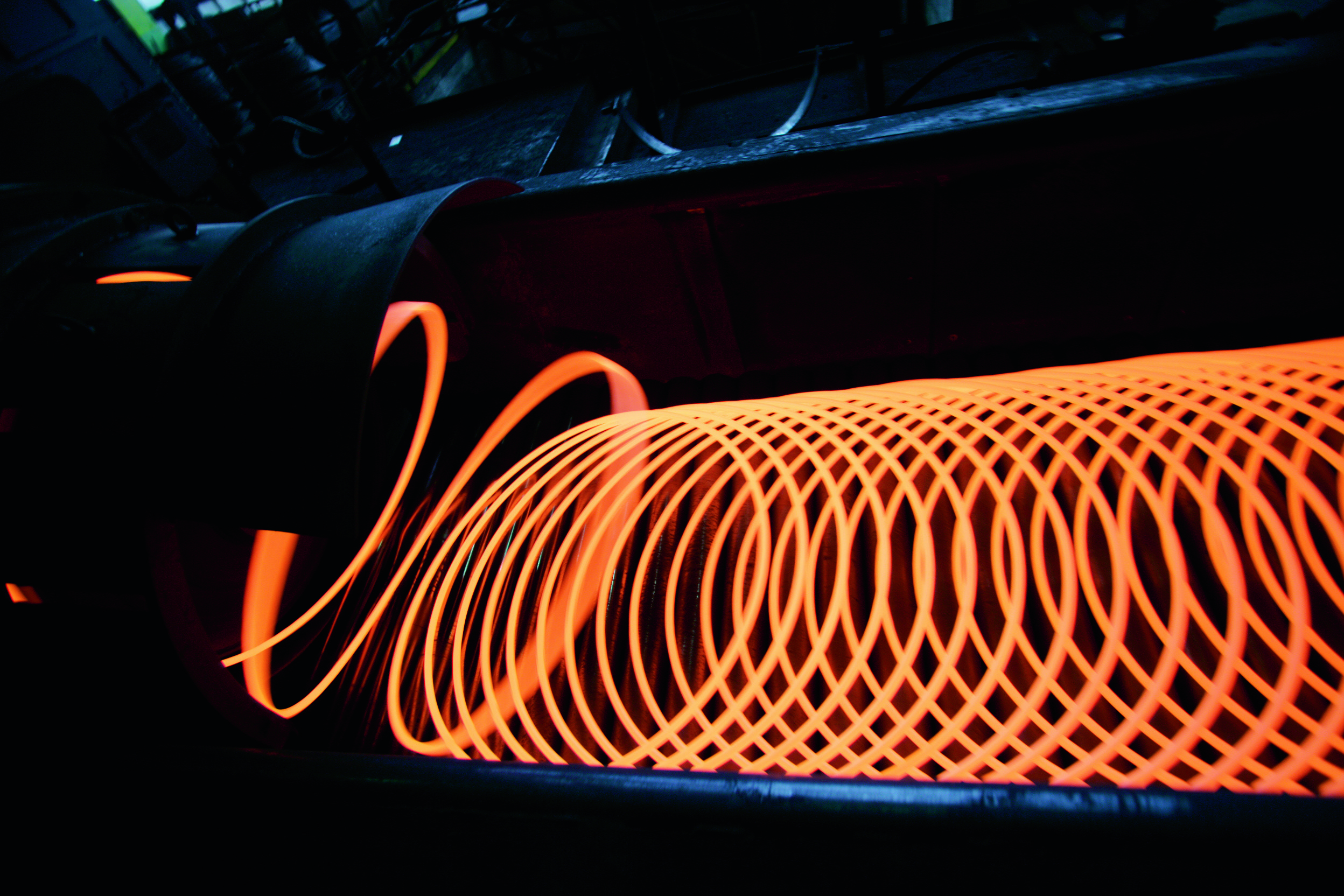 Glowing hot wire rod coil on dark background Glowing hot wire rod coil on dark background