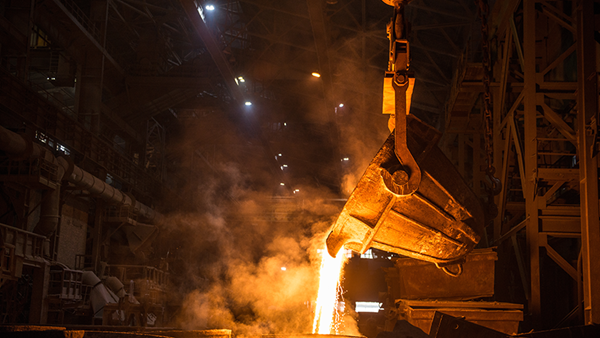 Ladle pouring liquid metal into molds at a steel mill. Ladle pouring liquid metal into molds at a steel mill.